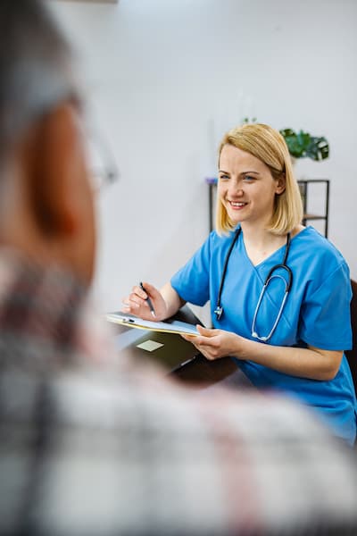 A nurse filling an onboarding document for a patient