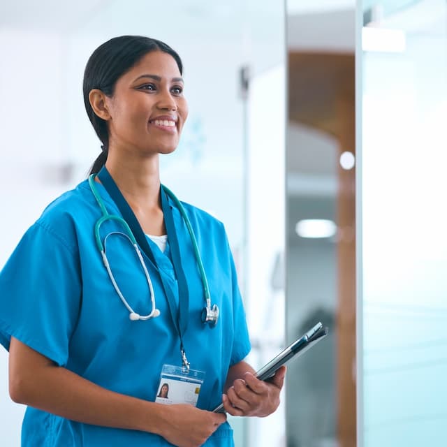 A smiling female doctor holding a tablet