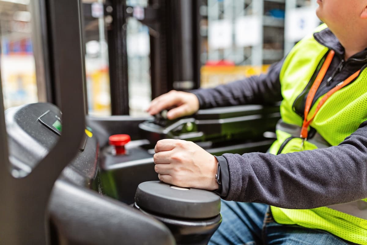 Close up of a forklift operator manoeuvring the controllers