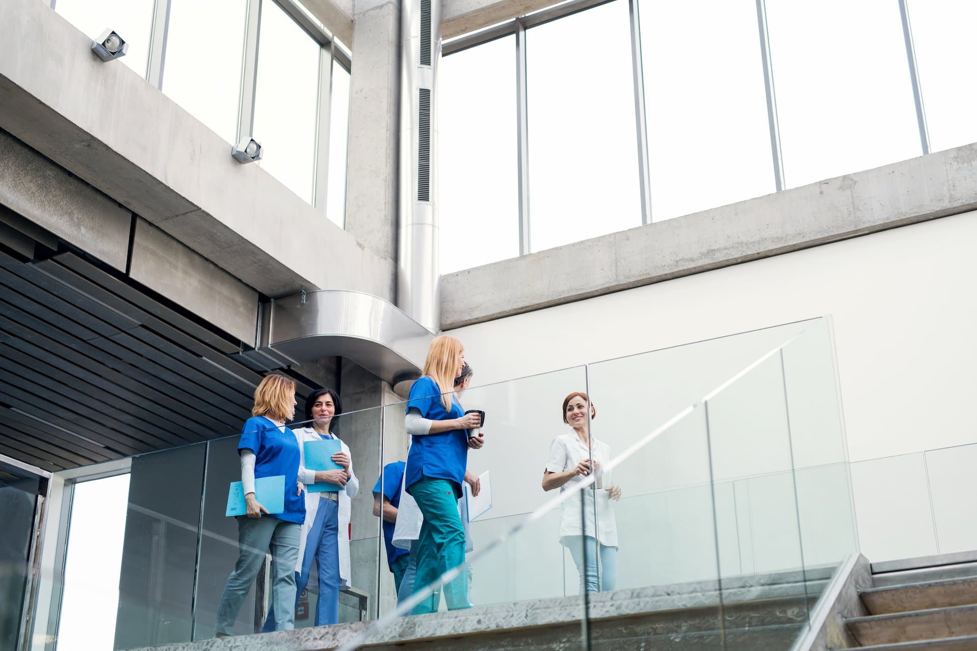 A group of doctors and nurses walking outside a hospital's builidng