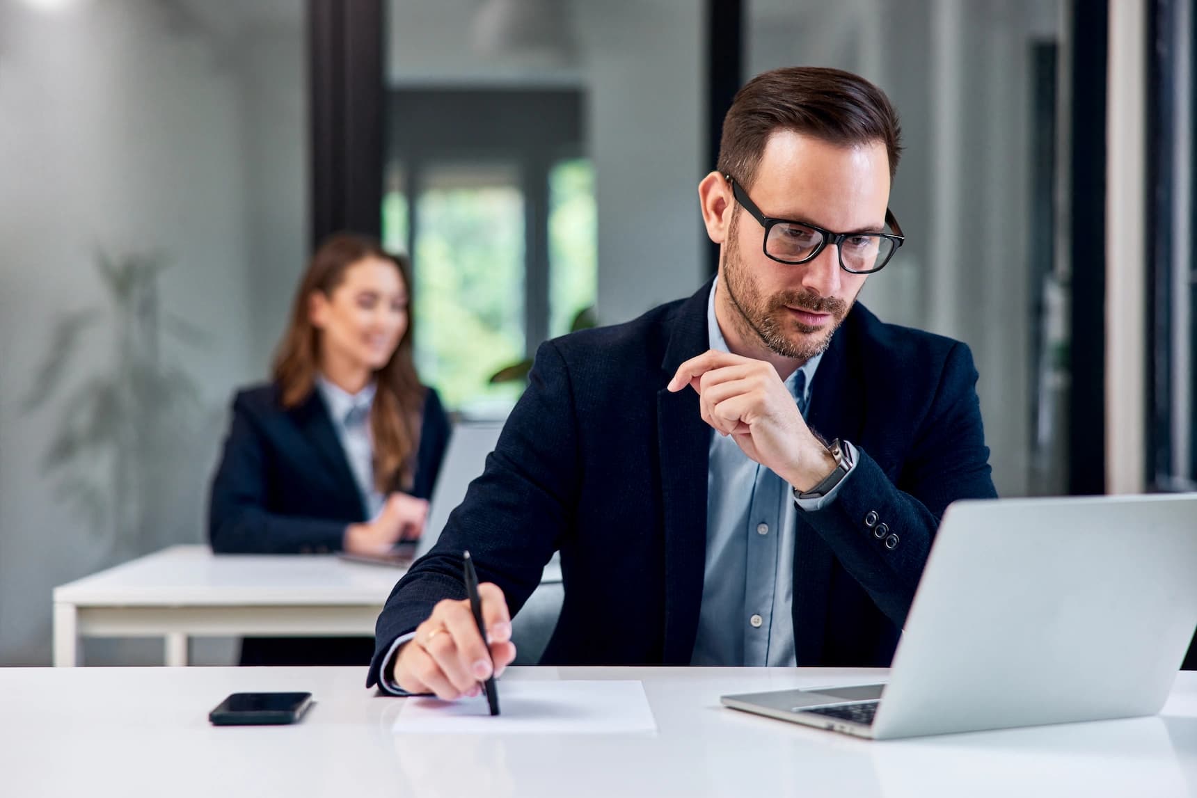 A focused business professional looking at his laptop