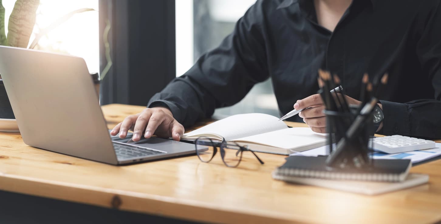 businessman working on laptop computer and paperwork