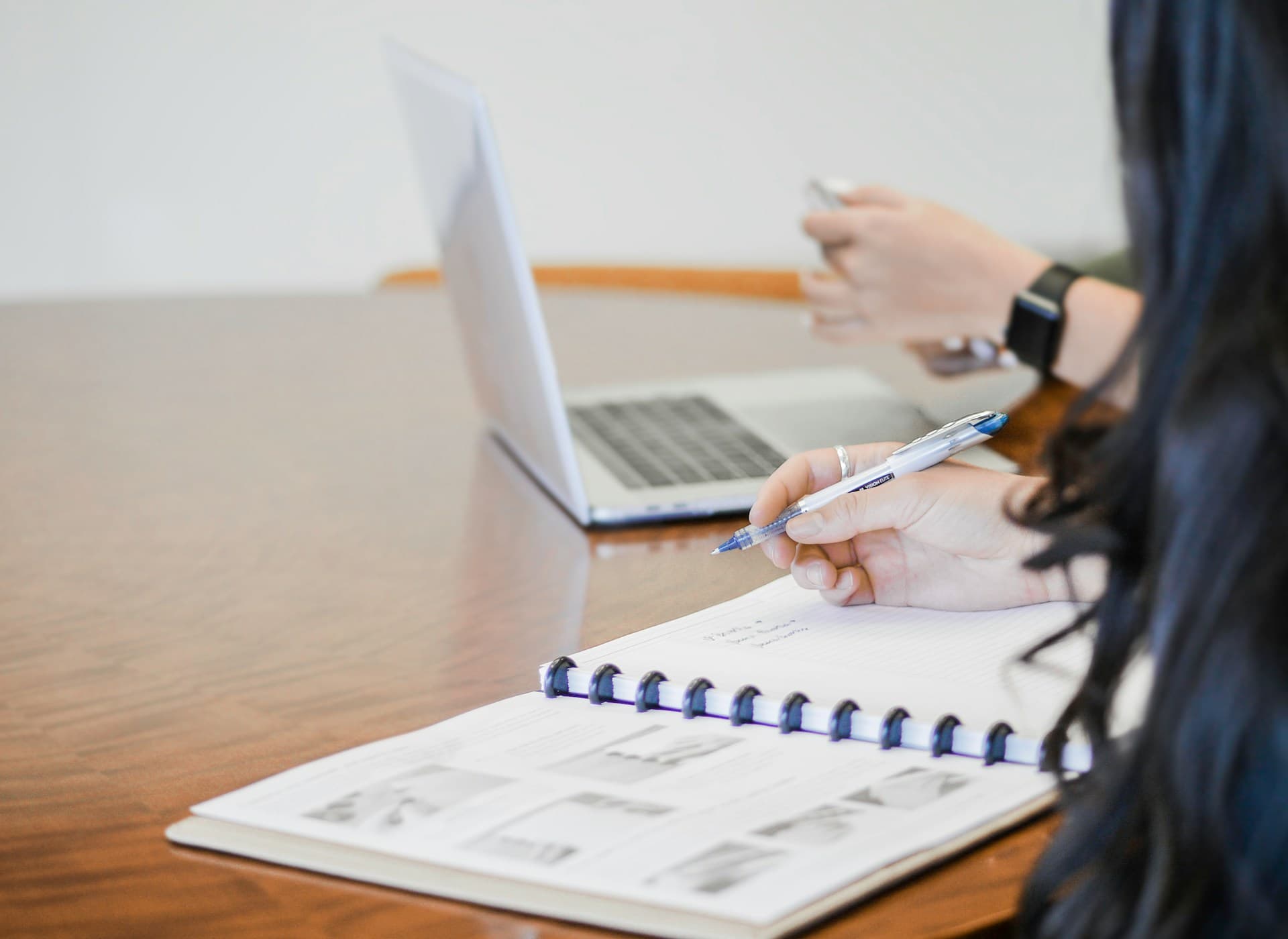 Details of. a female taking notes on a document