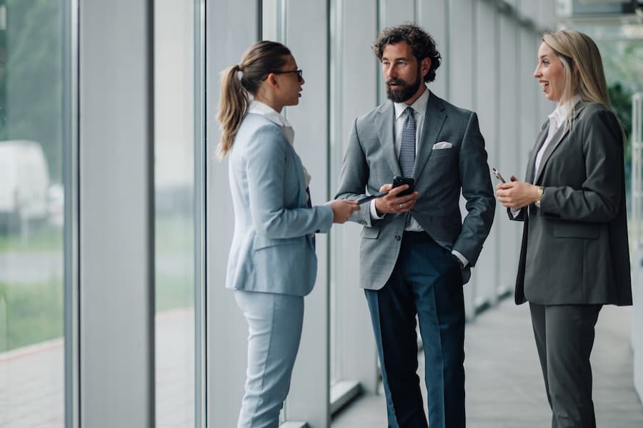 Business people discuss work in a modern office corridor