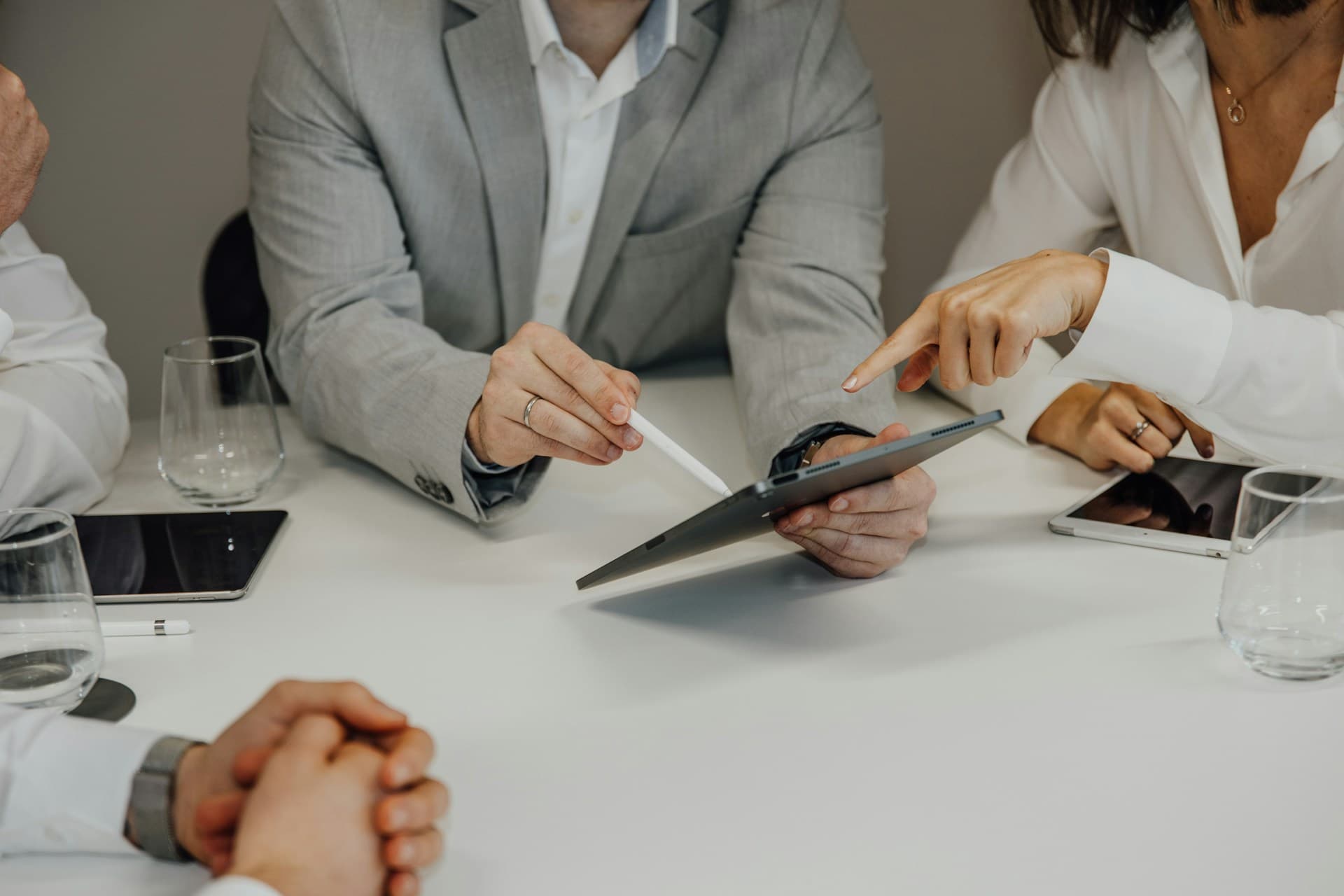 Two business people pointing at a tablet during a meeting