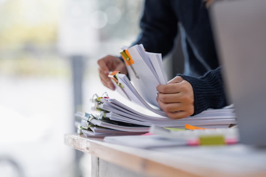 Close up of a woman searching through a pile of documents