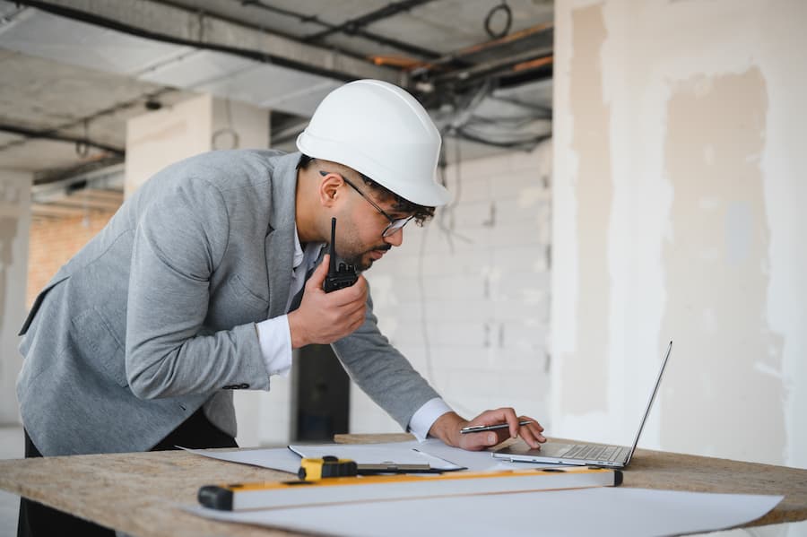 Construction Manager Working on Laptop at Building Site