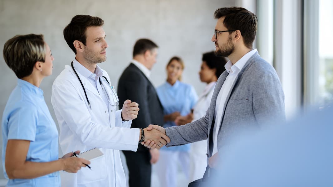 Professional handshake between doctor and businessman